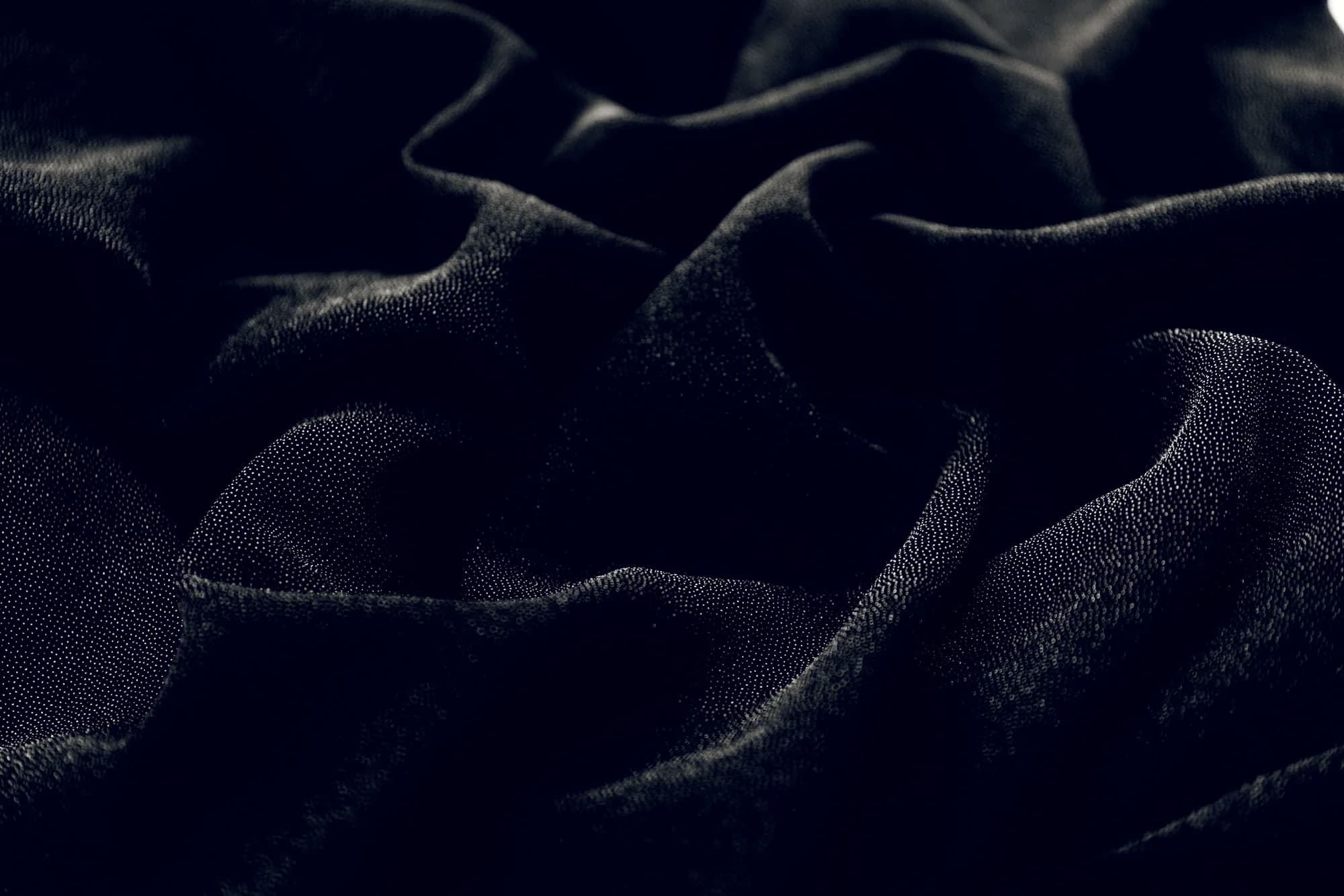 Layers of dark fabric in deep shadow.